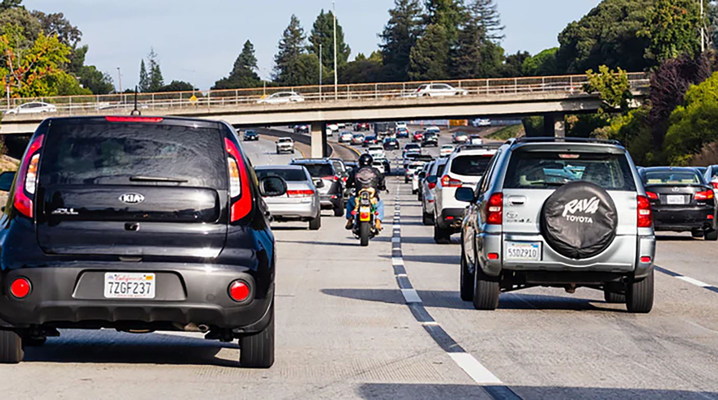 a biker lane splitting heavy traffic