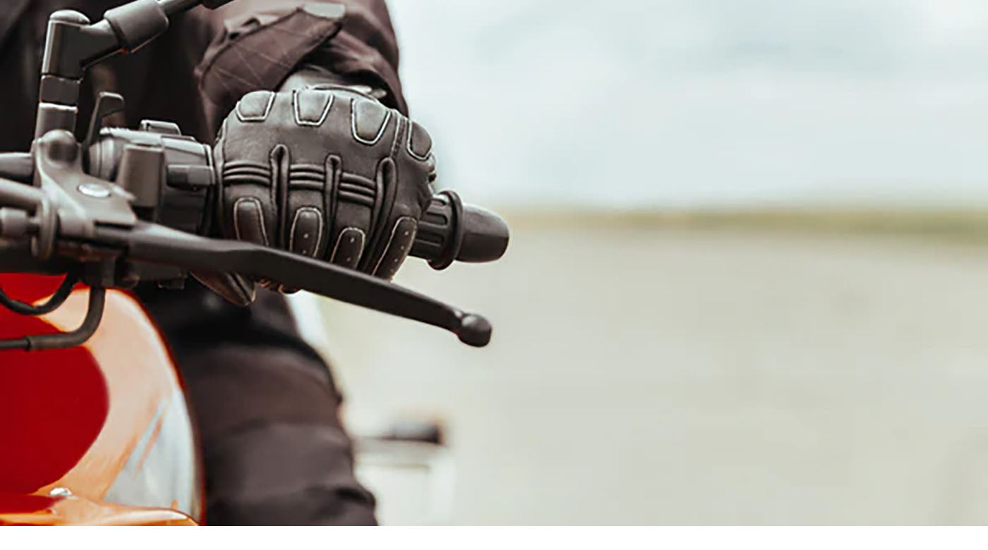 closeup shot of man's hand on motorcycle gears