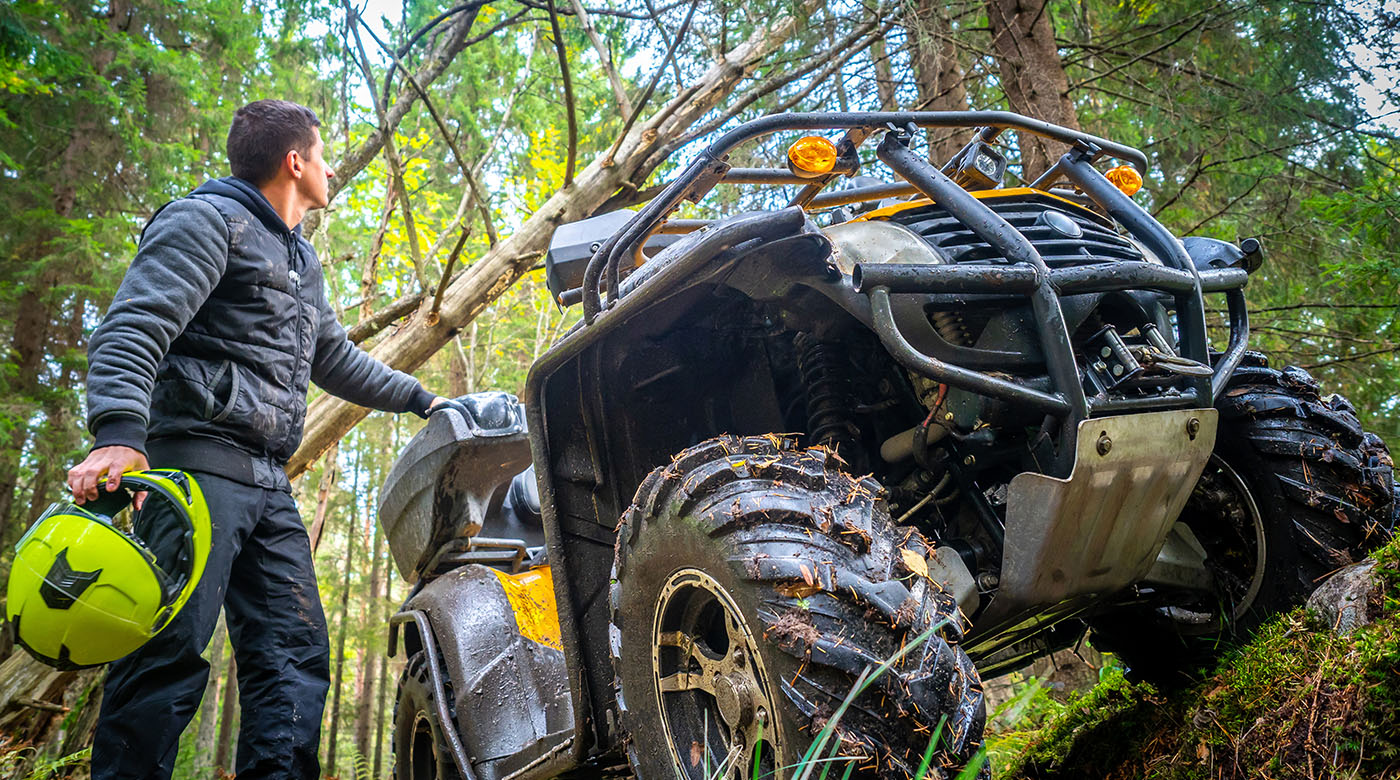 man in an all-terrain vehicle in the forrest