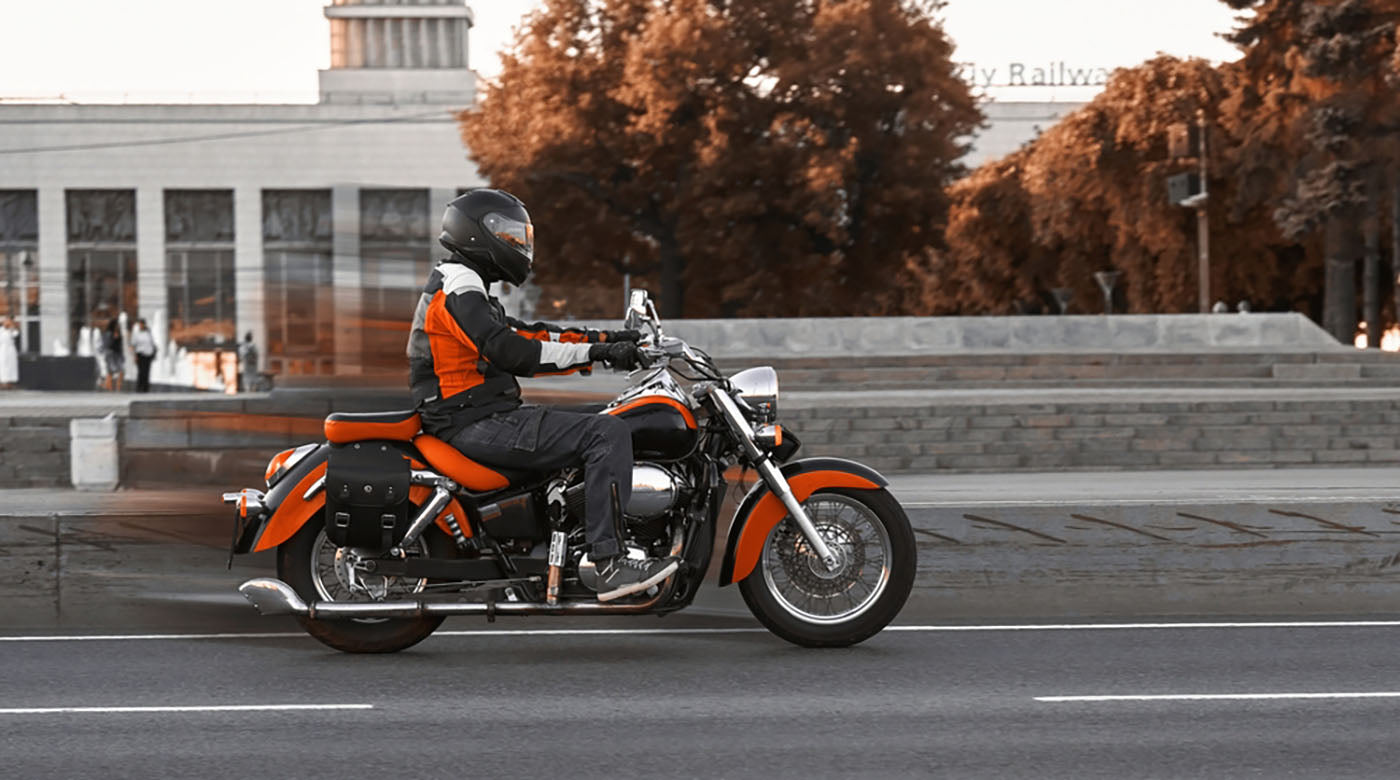 man on red cruiser motorcycle rides