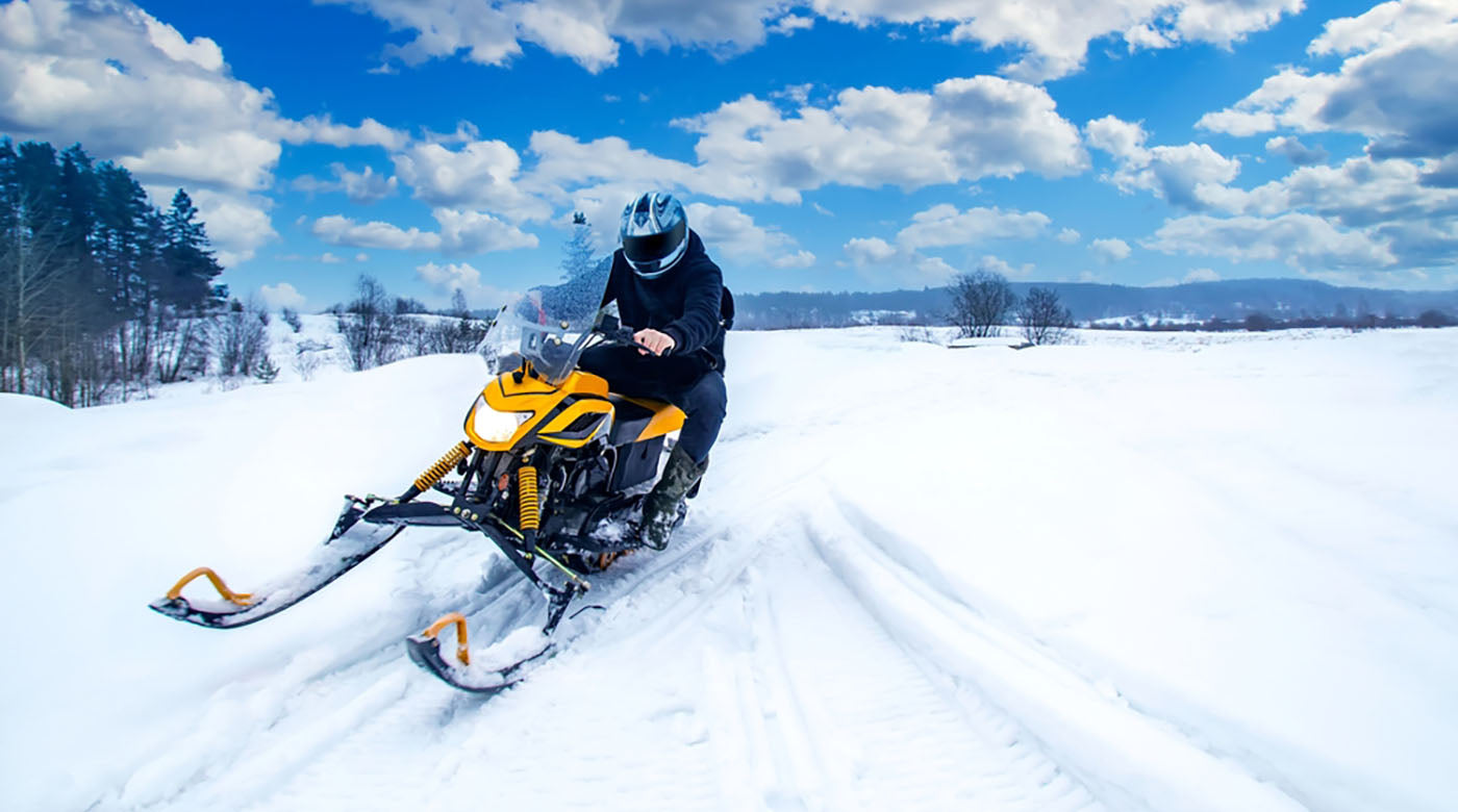 man rides snow mobile fast concept