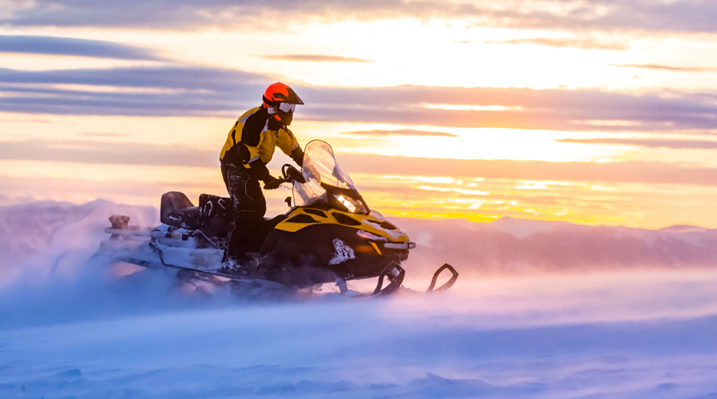 man riding snowmobile mountains