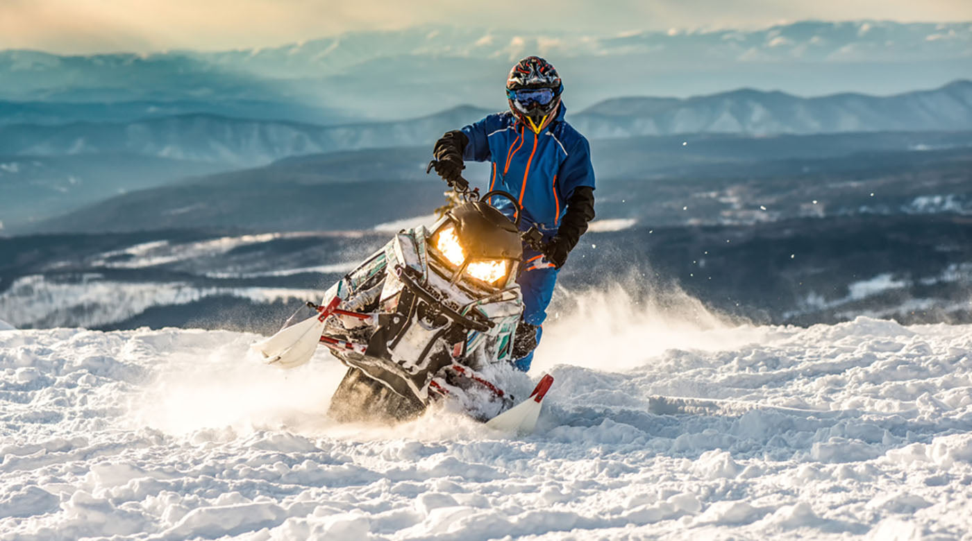 rider on snowmobile in mountains