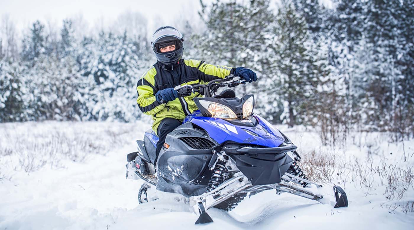 riding snowmobile through forest