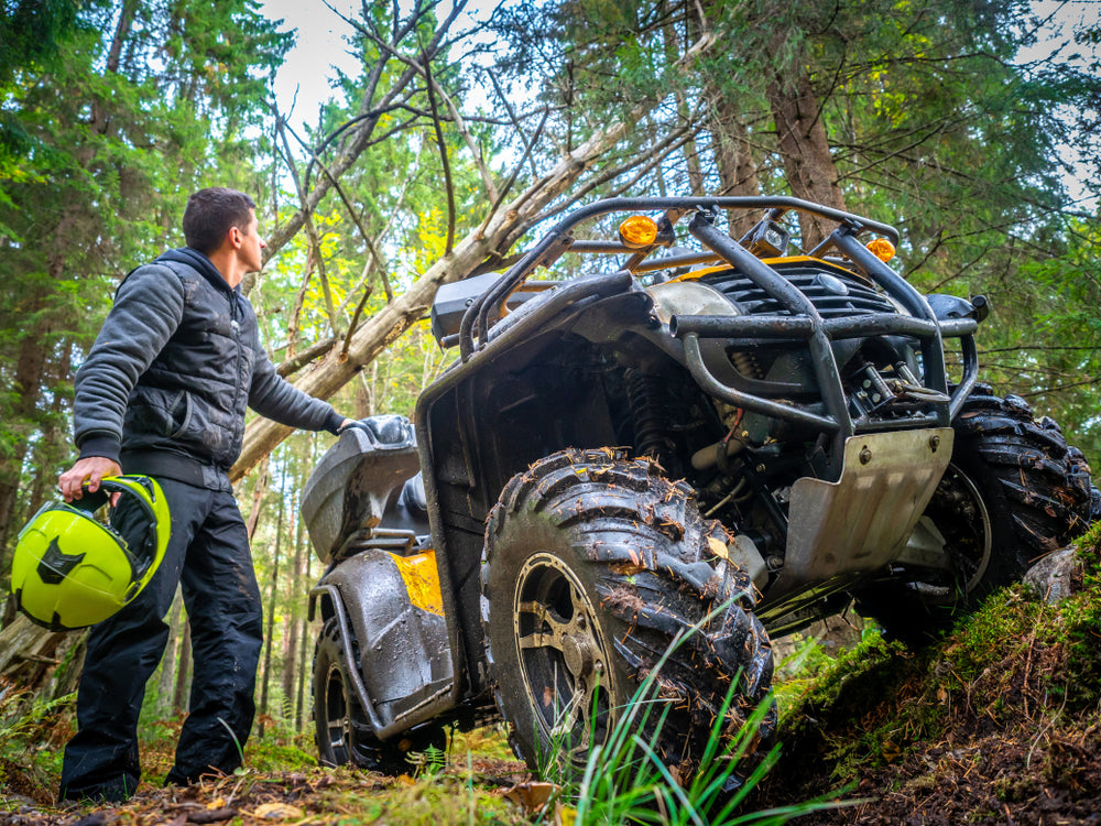 man in an all-terrain vehicle in the forrest