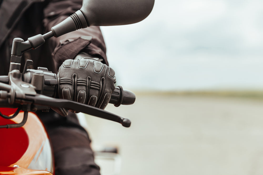 closeup shot of man's hand on motorcycle gears