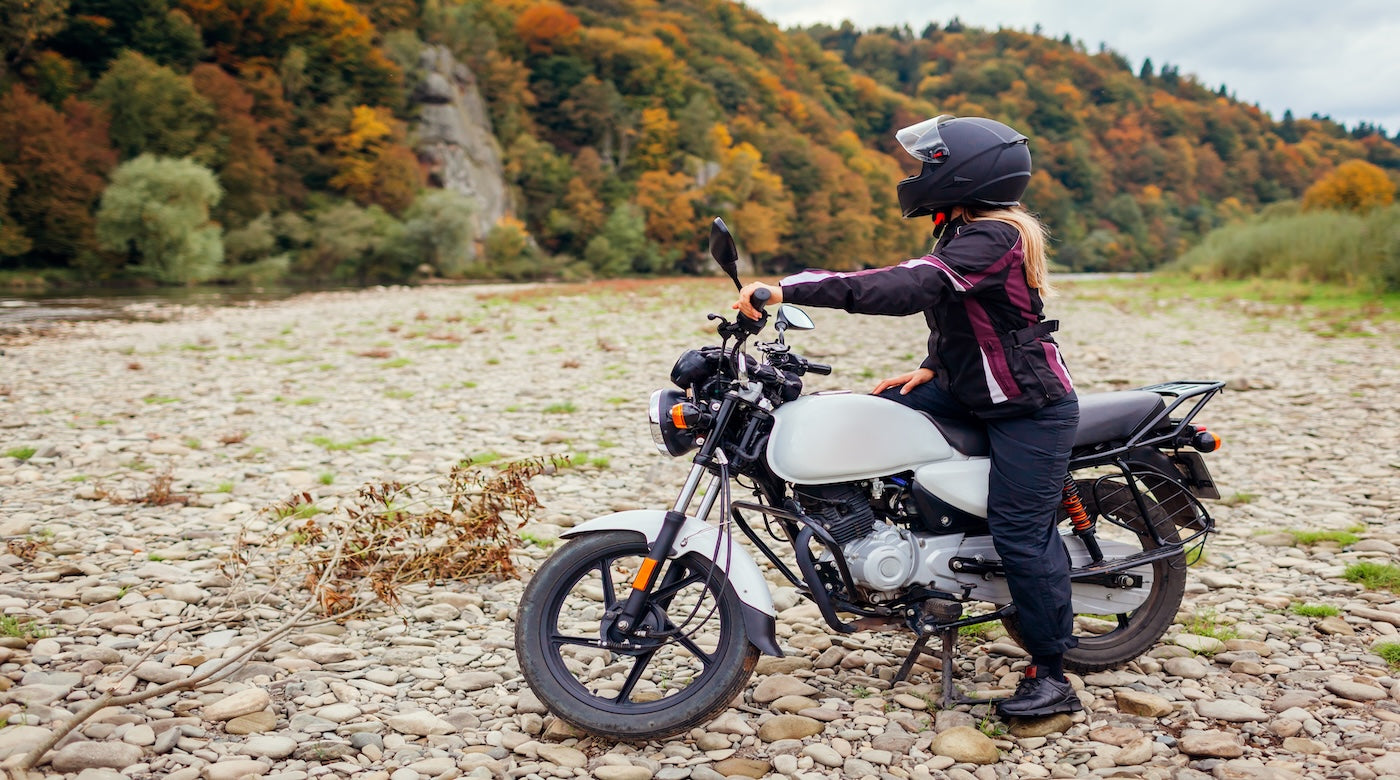 Woman biker travel by motorbike in fall