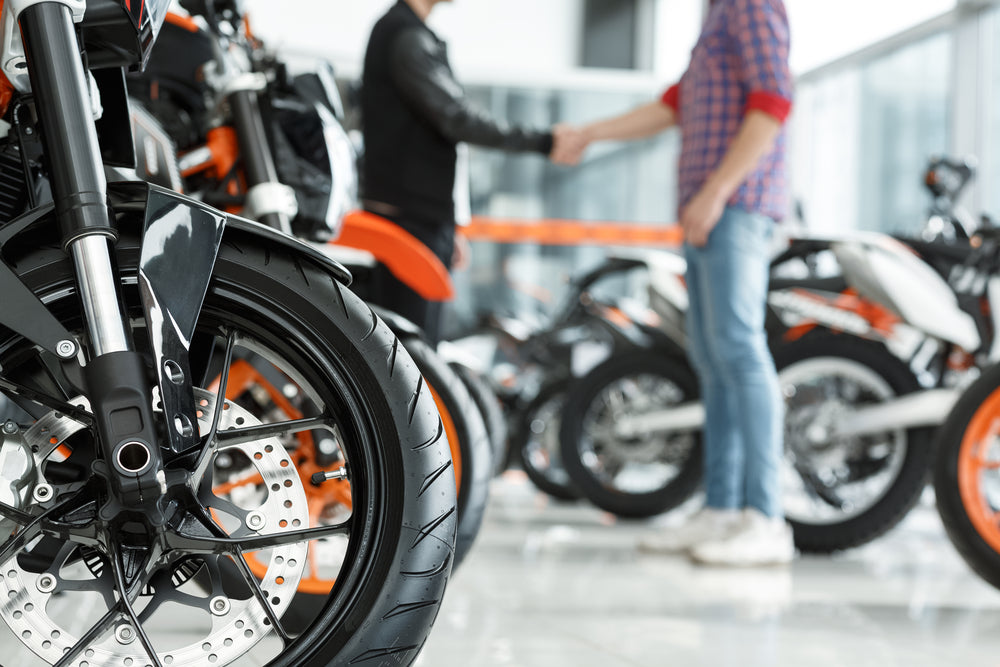 man shaking hands with motorcycle salesperson