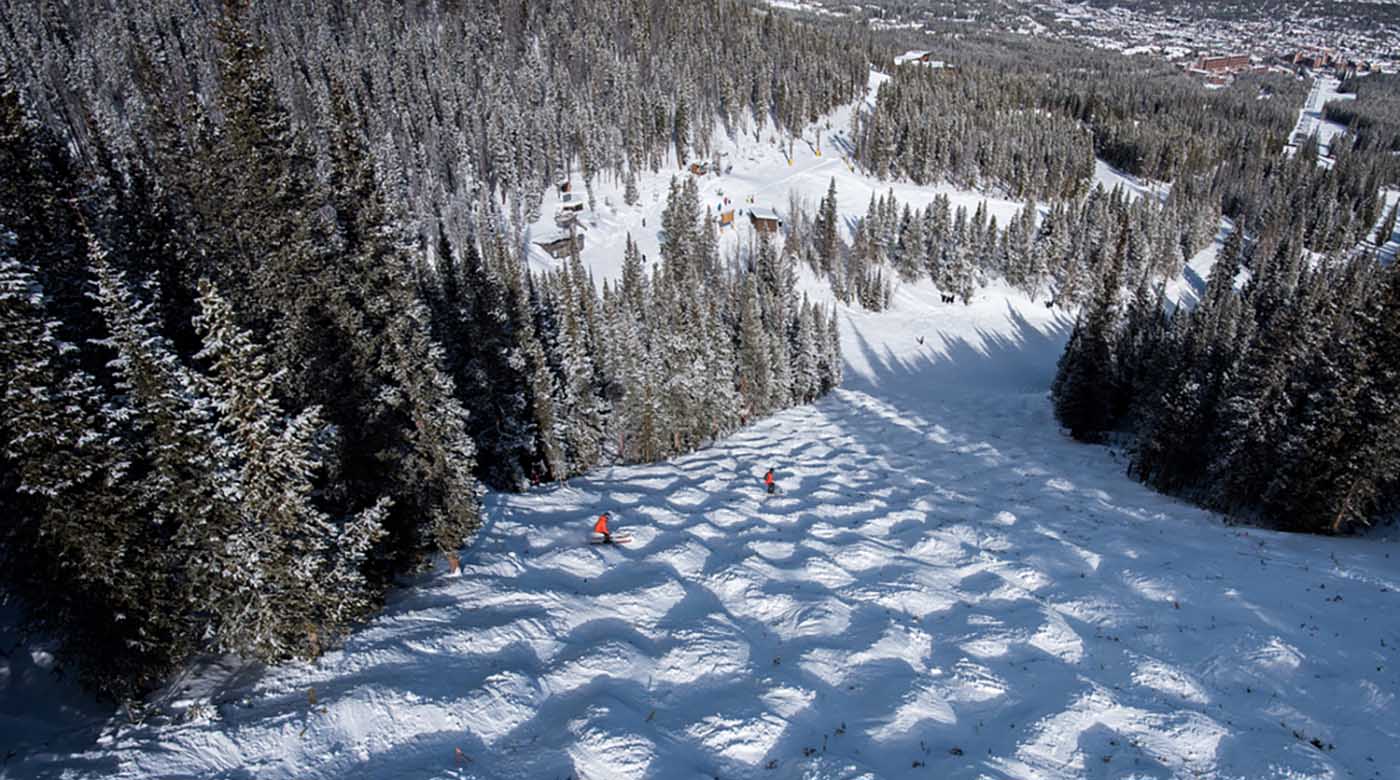 snowboarding down mountain slope