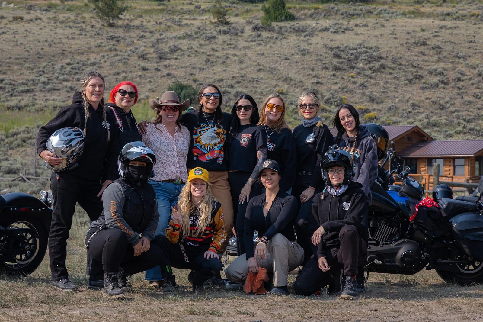 The Moto Girls posing together beside their motorcycles during a group trip.