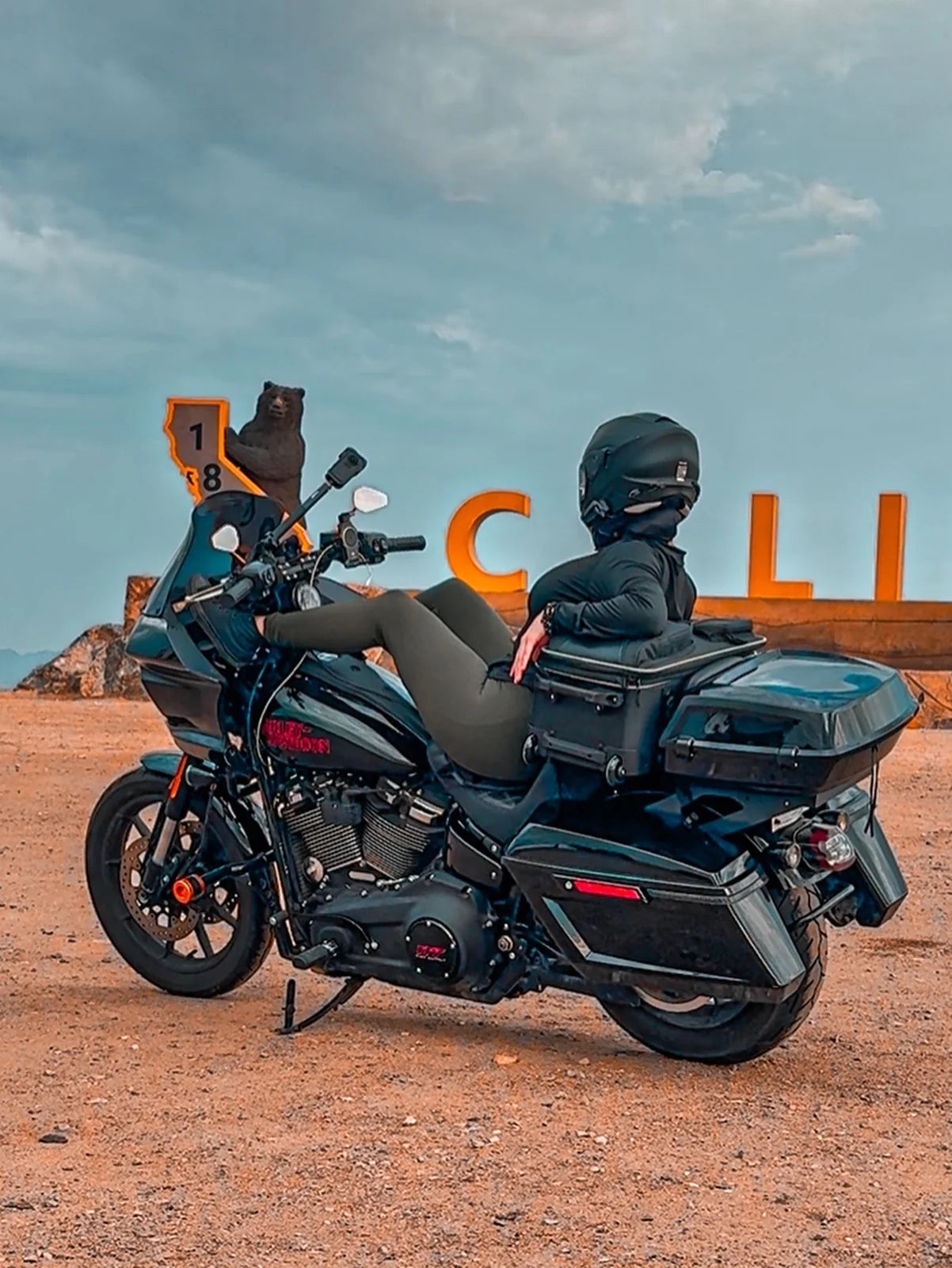 A rider seated on a touring motorcycle during a stop in the Utah desert.